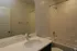 Modern bathroom featuring a sleek vanity, elegant fixtures, and a pristine bathtub for ultimate relaxation.