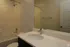 Modern bathroom with elegant fixtures, featuring a sleek vanity, polished countertop, and spacious shower area.