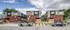 Modern townhouse complex with sleek architecture, vibrant red brick facade, lush landscaping, and contemporary design, offering stylish urban living.