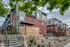Chic urban townhouse with modern brick facade, lush landscaping, and inviting entrance set in a vibrant neighborhood.