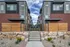 Modern urban townhouse entrance featuring sleek architecture with brick and glass exterior, complemented by stylish wooden fencing and landscaping.