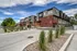 Modern townhouse complex showcasing sleek architecture with brick and glass facade, situated in a beautifully landscaped setting.