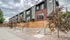 Modern townhouses with stylish stone and brick facades, elegant wooden fencing, and well-maintained garden paths, perfect for urban living.