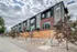 Modern townhouses with sleek design and large windows, nestled in a serene urban neighborhood.
