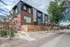 Contemporary three-story apartment complex with modern design, featuring large windows, red brick facade, and landscaped entrance. Ideal urban living space with easy sidewalk access and stylish exterior.
