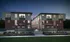 Modern townhouse complex with stylish brick and panel facade, illuminated by cozy lights, surrounded by lush landscaping at dusk.