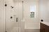 Elegant bathroom featuring a glass-door walk-in shower, modern fixtures, and a soaking tub with natural light.