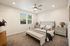 Elegant bedroom with modern design, featuring a plush bed, stylish nightstands, and natural light from large windows.