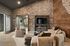 Luxurious living room featuring a modern stone accent wall, cozy seating, and a sleek built-in fireplace beneath a large flat-screen TV.