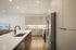 Modern kitchen with sleek cabinetry, stainless steel appliances, and a spacious island with a stylish faucet, perfect for culinary enthusiasts.