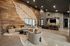 Modern living area featuring elegant sofas, a unique wood panel wall with artistic design, and an inviting open dining space.