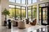 Bright and inviting living area with modern decor, featuring large floor-to-ceiling windows revealing a scenic outdoor view.
