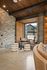 Chic apartment corner with plush seating, textured stone wall, and warm wooden accents offering a cozy, stylish ambiance.