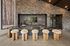 Elegant kitchen with luxurious marble counter, chic bar stools with plush fur tops, and rustic stone wall for a cozy-modern charm.