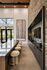 Luxurious open-concept kitchen with a striking stone wall, elegant island seating with plush stools, and large artwork enhancing the sophisticated interior design.