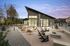 Chic modern patio with elegant seating areas and a cozy fire pit, set against a stylish building at twilight.