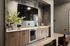 Sleek modern kitchenette with stylish cabinetry, built-in appliances, and elegant decor, perfect for contemporary urban living.