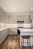 Modern kitchen with sleek cabinetry, stainless steel appliances, and elegant wood flooring providing a stylish and functional space.