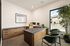 Modern office space with sleek wooden furniture, large window view, and lush indoor plants for a serene work environment.