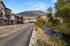 Charming riverside townhouses with scenic mountain views, surrounded by lush greenery and a tranquil stream.