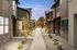 Charming outdoor walkway lined with modern townhouses and ambient string lights, creating a welcoming and serene community ambiance.