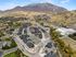 Breathtaking aerial view of a modern residential complex surrounded by scenic mountains and lush greenery, offering serene living in harmony with nature.