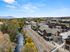 Charming riverside neighborhood with modern homes and picturesque walkways, nestled amidst vibrant autumn foliage.