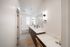 Elegant bathroom featuring double vanity sinks, bright lighting, and a stylish bathtub with modern fixtures.