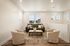 Bright and inviting living room with modern decor, featuring a cozy sofa, stylish armchairs, and large windows allowing natural light to flood the space.