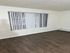Bright and airy living space with stylish wooden floors and large window blinds, perfect for a cozy ambiance.