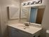 Chic and modern bathroom vanity with sleek lighting, bright mirror, and elegant fixtures.