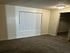 Cozy bedroom with plush carpeting and ample closet space, featuring a bright window for natural light.