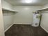 Spacious walk-in closet featuring dual hanging rods and a modern water heater, enhancing storage utility.