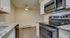 Modern kitchen with sleek granite countertops, stainless steel appliances, and elegant lighting, perfect for culinary enthusiasts.