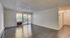 Bright and spacious living room featuring modern hardwood floors, large windows, and a serene view.