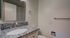Elegant bathroom with modern granite countertop, sleek silver fixtures, and a large mirror, offering a touch of luxury and style.