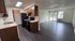 Modern open-plan layout featuring a sleek kitchen with dark wood cabinets, adjacent to a bright living area with large windows.