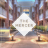 Elegant entryway at The Mercer, showcasing modern architecture with warm lighting and lush greenery.