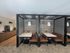 Modern communal dining area with stylish booths, elegant pendant lighting, and a sleek coffee station, perfect for gatherings.