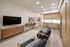 Modern open-concept living area with cozy seating, a sleek entertainment unit, and a stylish, fully-equipped kitchen with wood accents.