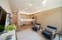 Modern open-concept living space with sleek kitchen, cozy lounge area, and stylish wooden cabinetry.