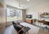 Bright and modern living room with chic decor, large window with courtyard view, and stylish furniture arrangement.