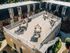 Charming apartment complex with a spacious rooftop patio, featuring elegant seating areas under umbrellas, perfect for outdoor relaxation.