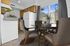 Charming kitchen and dining area with natural light, featuring wood cabinets, modern appliances, and cozy seating with a scenic outdoor view.