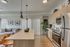 Modern open-concept kitchen and living area with sleek appliances, elegant lighting, and contemporary decor.