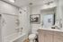Modern bathroom featuring a stylish vanity, framed artwork, and elegant lighting, creating a serene and inviting atmosphere.