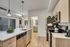 Modern kitchen with sleek stainless steel appliances, elegant pendant lighting, and a stylish island with a built-in sink, offering a contemporary living experience.