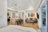 Modern open-concept studio apartment with sleek kitchen, cozy living area, and vibrant artwork on the wall.