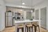 Modern kitchen with sleek cabinetry, stainless steel appliances, and a stylish island with bar stools, perfect for entertaining.