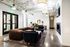 Modern apartment lobby with chic leather and velvet seating, stylish lighting, and vibrant area rug creating an inviting ambience.